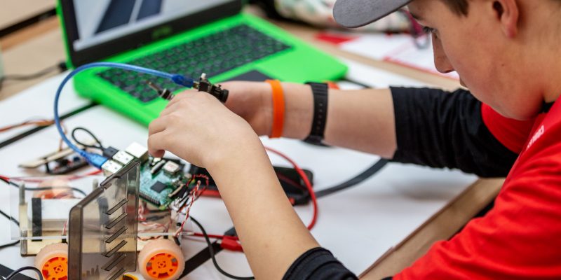 A boy working on a Raspberry Pi robot buggy.