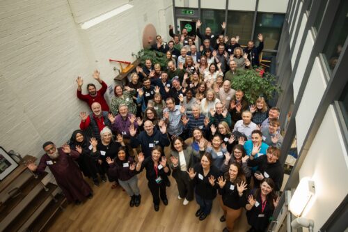 Fifty teachers and researchers posing for a photo at the AI Symposium, held at the Raspberry Pi Foundation office.