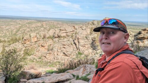 Photo of Al out hiking in rocky terrain.