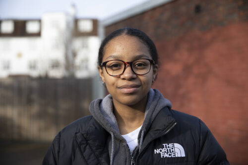 A young teenager with glasses smiles