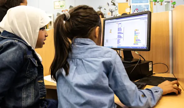 Two girls working together on a programming task