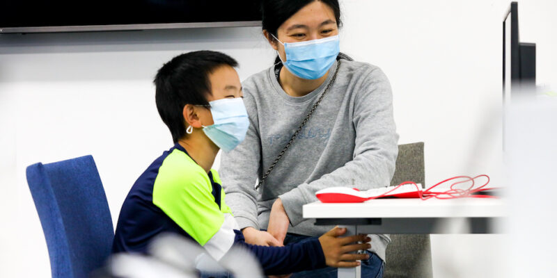 A parent and child work together at a Raspberry Pi computer.