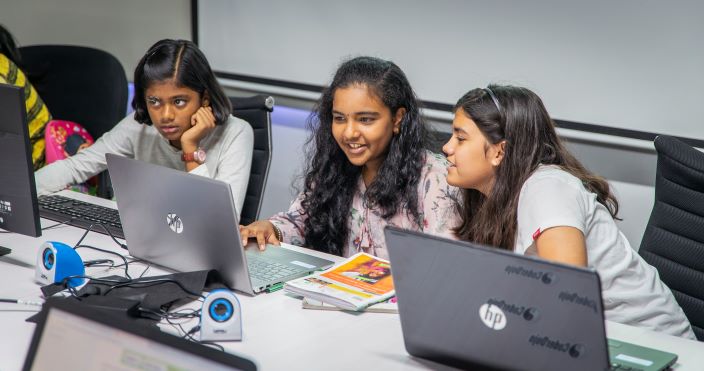 Three learners working at laptops.