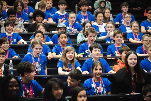 Photo of young creators getting ready to cheer, whilst attending an in-person Coolest Projects event.