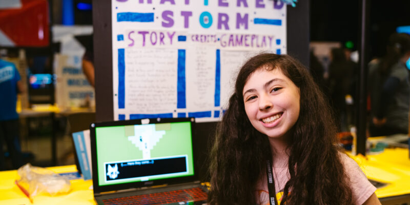 A teenage girl participating in Coolest Projects shows off her tech project.