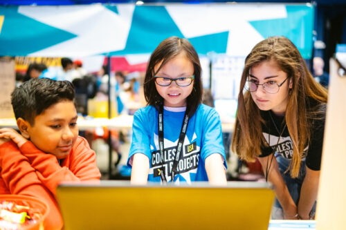 A young coder shows off her tech project Five young coders show off their robotic garden tech project for Coolest Projects to two other young tech creators.