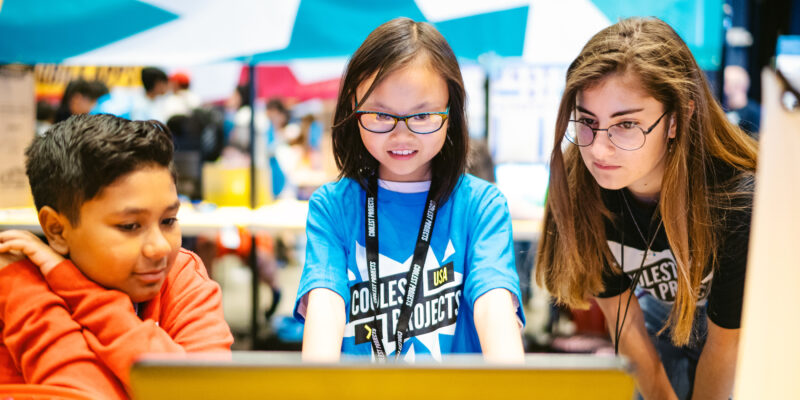 A young coder shows off her tech project Five young coders show off their robotic garden tech project for Coolest Projects to two other young tech creators.