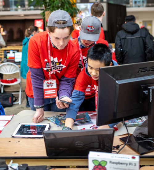 Three young people working together on a tech project.