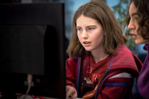 Close up of two young people working at a computer.