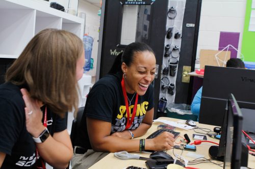 A teacher attending a training workshop laughs as she works through an activity.