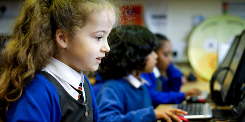 In a computing classroom, a girl looks at a computer screen.