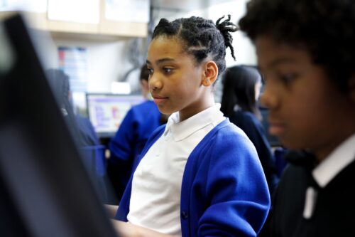 Two learners in a computing classroom.