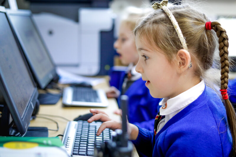 In a computing classroom, a girl looks at a computer screen.