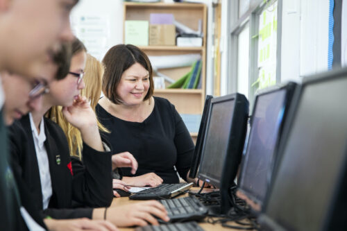 A computing teacher and students in the classroom.