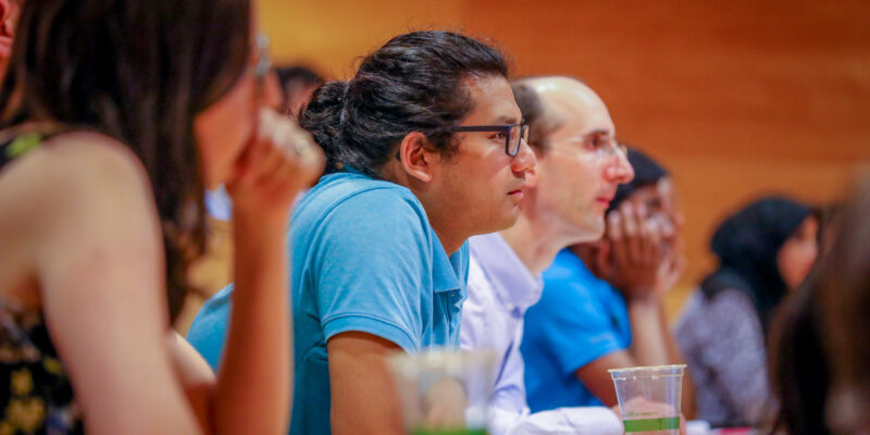 Educators and researchers listen to a talk at a conference.