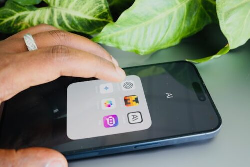 A finger clicking on an AI app on a phone. 