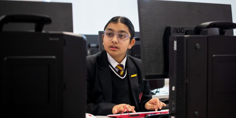 A secondary school age learner in a computing classroom.