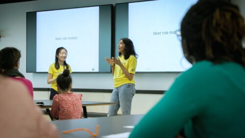 Two mentors deliver a presentation during a CoderDojo session. 