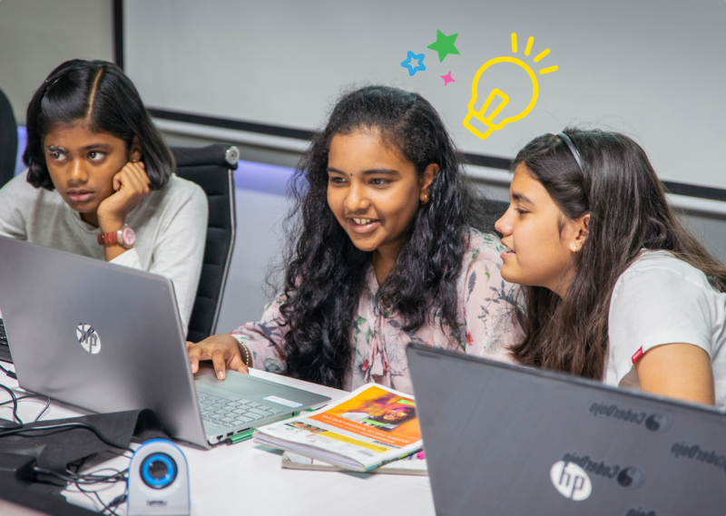 Three young tech creators at laptops at a Code Club session.