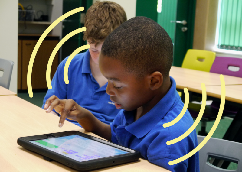 A young tech creator at a tablet at a Code Club session.