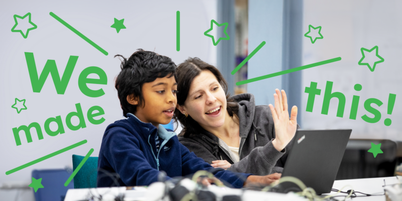 Two mentors and a young tech creator at a laptop at a Code Club session.