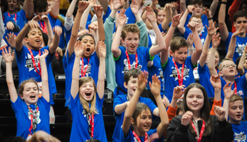 Young people raising their hands in the air. 