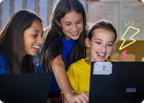 Three young tech creators at laptops at a Code Club session.