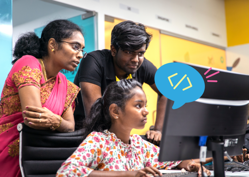 Two mentors and a young tech creator at a computer at a Code Club session.