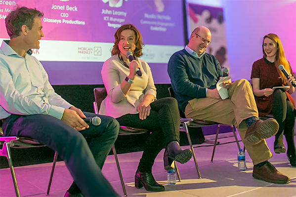 People sitting in conversation on a panel.