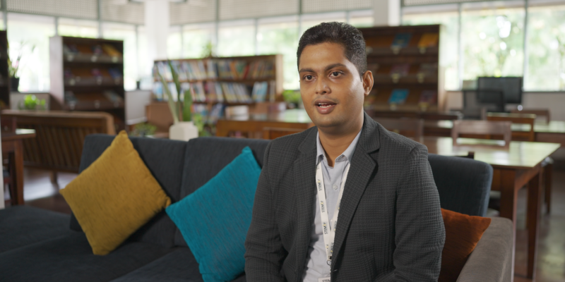 An educator sits in a library.