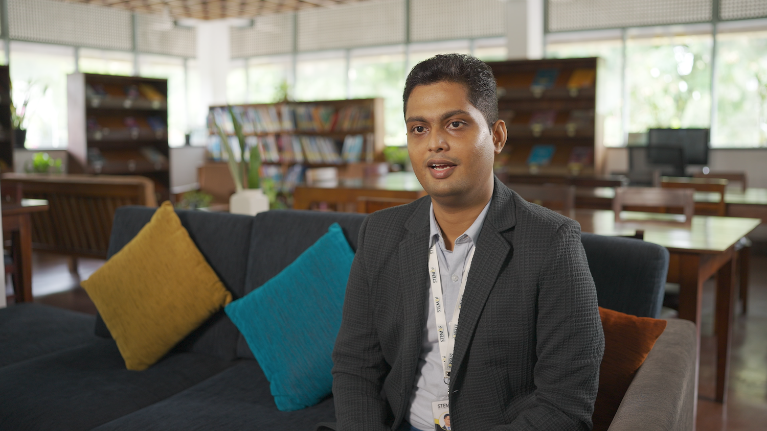 An educator sits in a library.