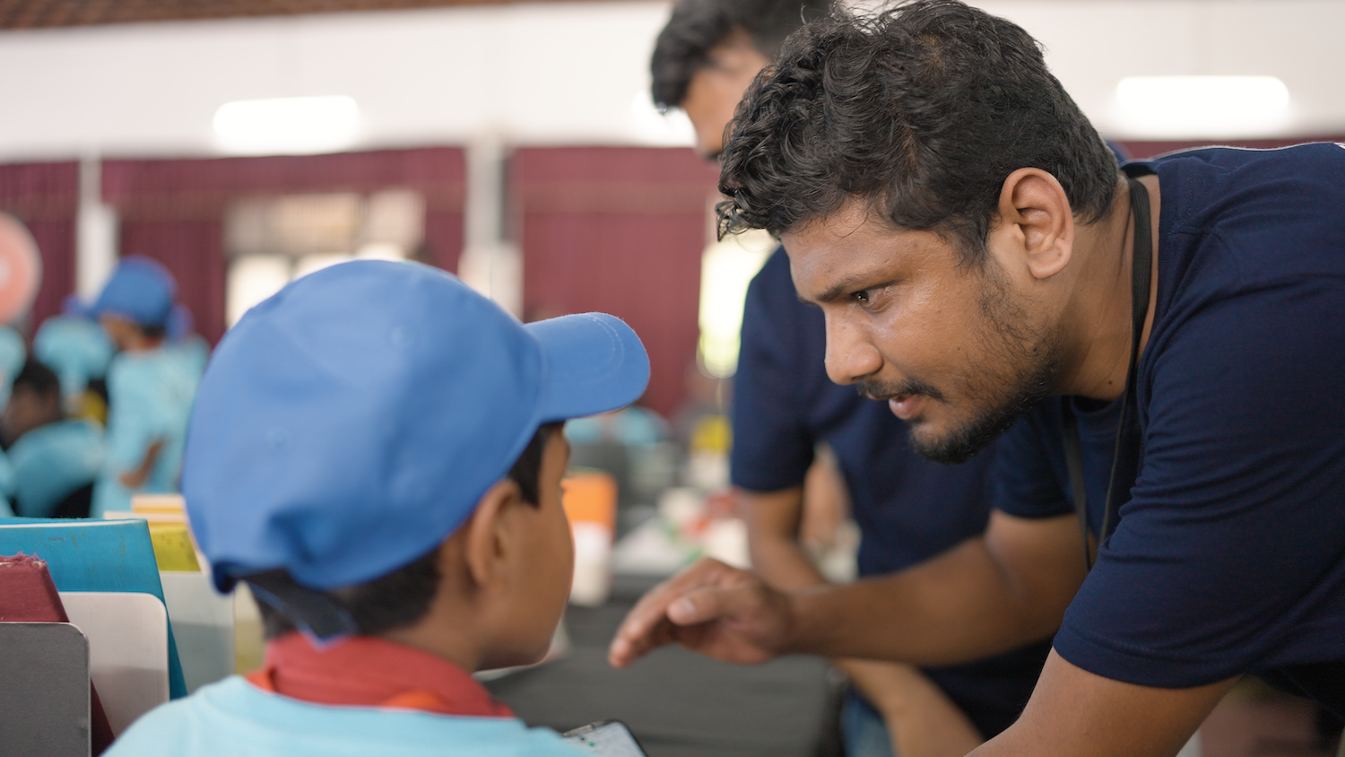 An educator helps a young person at a Code Club. 